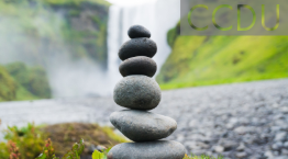 Stones piled on top of each other with waterfall in background